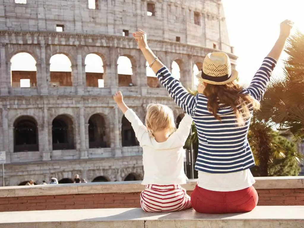 woman and child seen from the back looking at Rome Colosseum