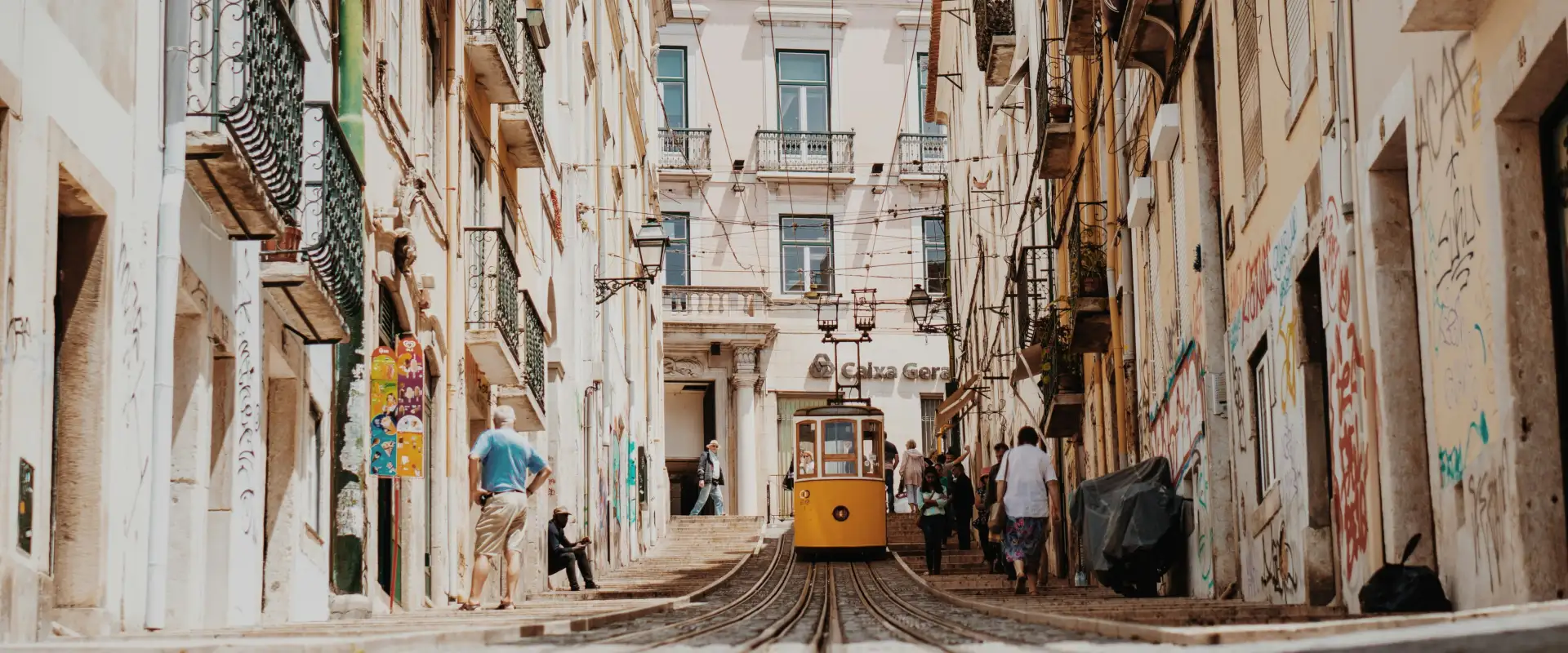 A tram drives down an alley in Lisbon, Portugal