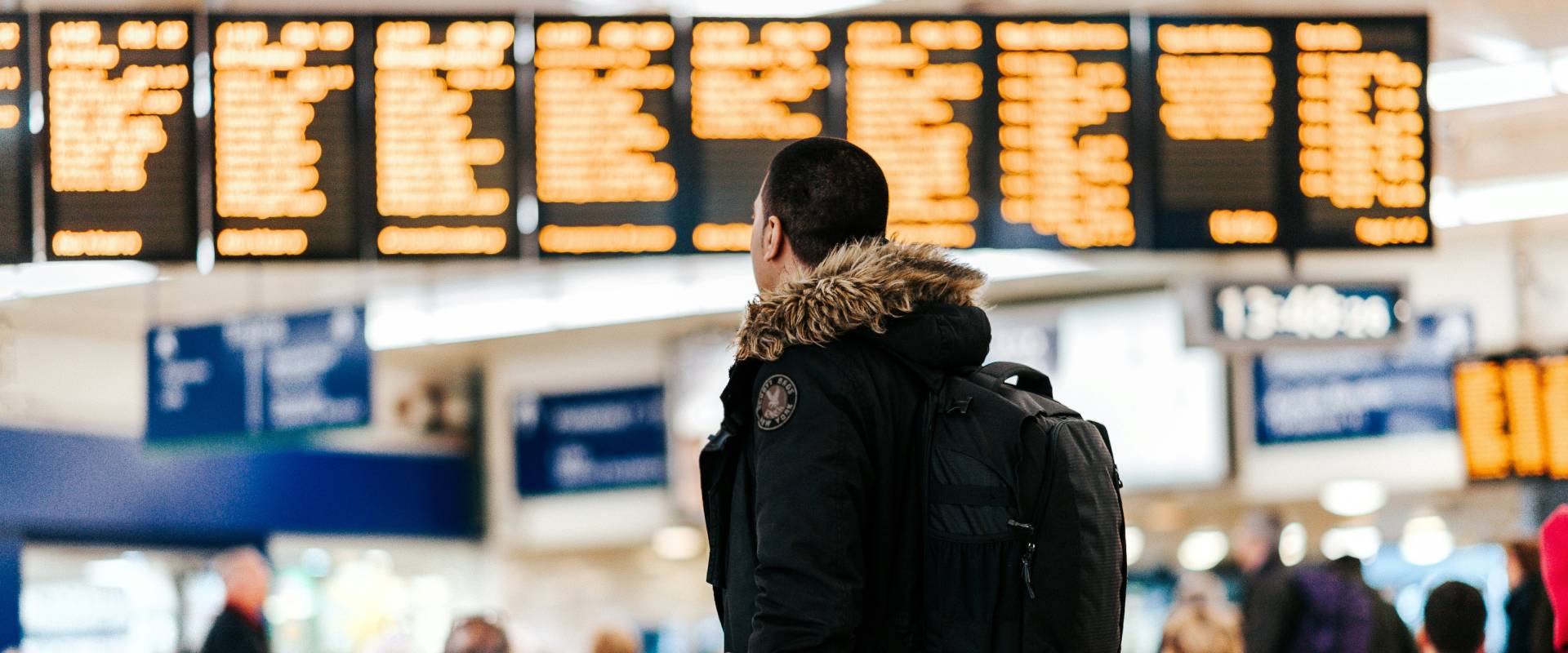 Man stands in front of screen at airport