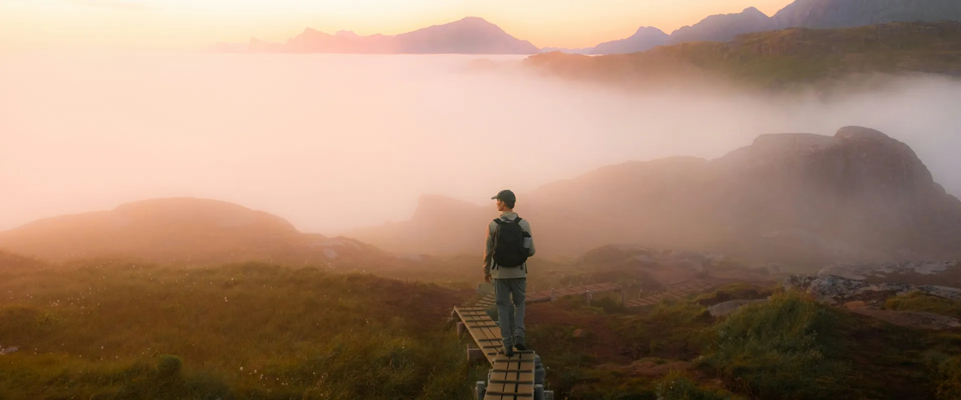 Man hiking among clouds in the mountains