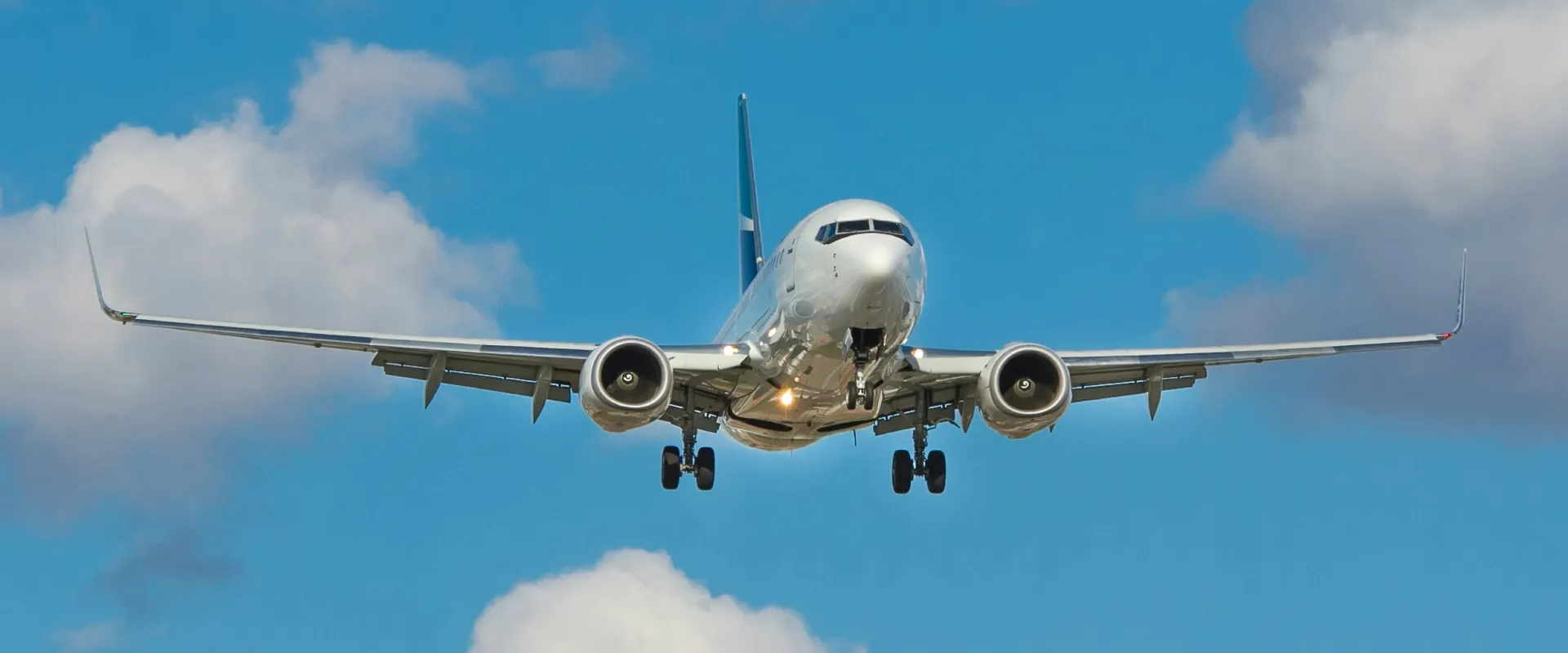 Plane flying in blue sky with clouds